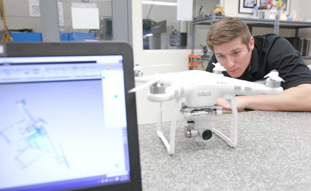 ECM technician adjusting scanner settings while scanning a remote drone