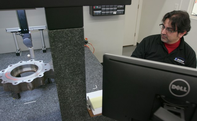 ECM technician scanning a machined component using a CMM