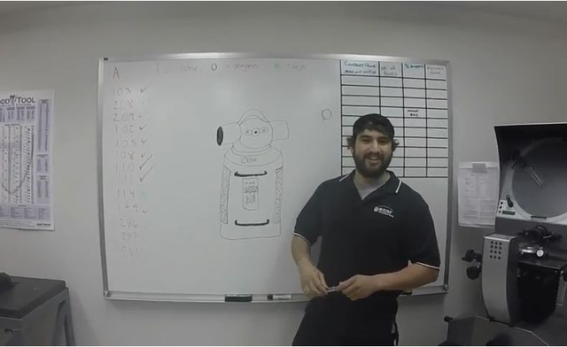 technician standing in front of a whiteboard demonstrating how to clean an SMR