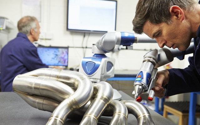 metrologist using portable arm to measure piping