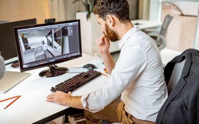 metrology student sitting at desk working on a CAD model