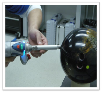 laser scanner taking a measurement of a bowling ball