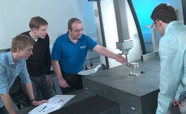 NPL instructor demonstrating a CMM to several young students